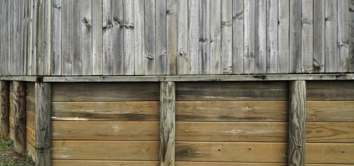 Timber retaining wall beneath timber fence