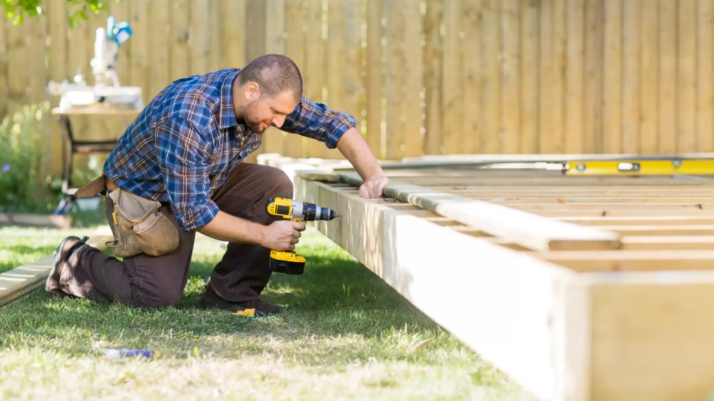 Man assembling NZ deck using pinewood decking timber